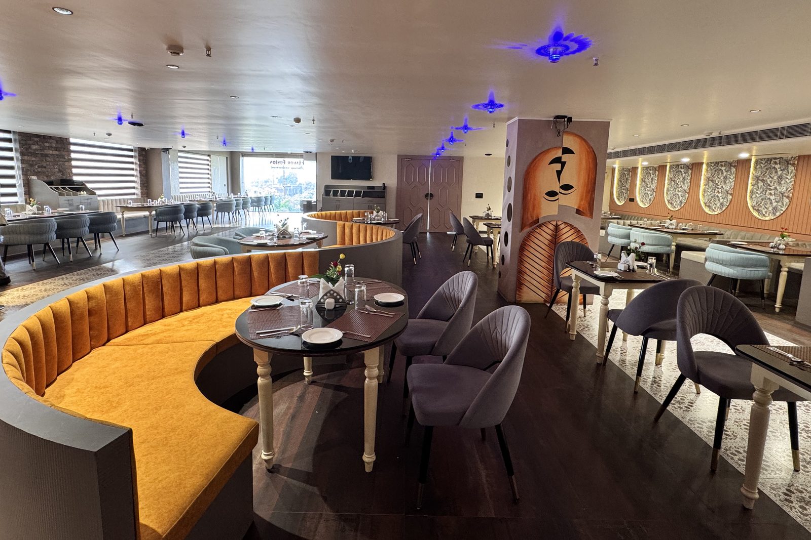 A broad view of Flavor Fusion with curved golden booths and dining tables