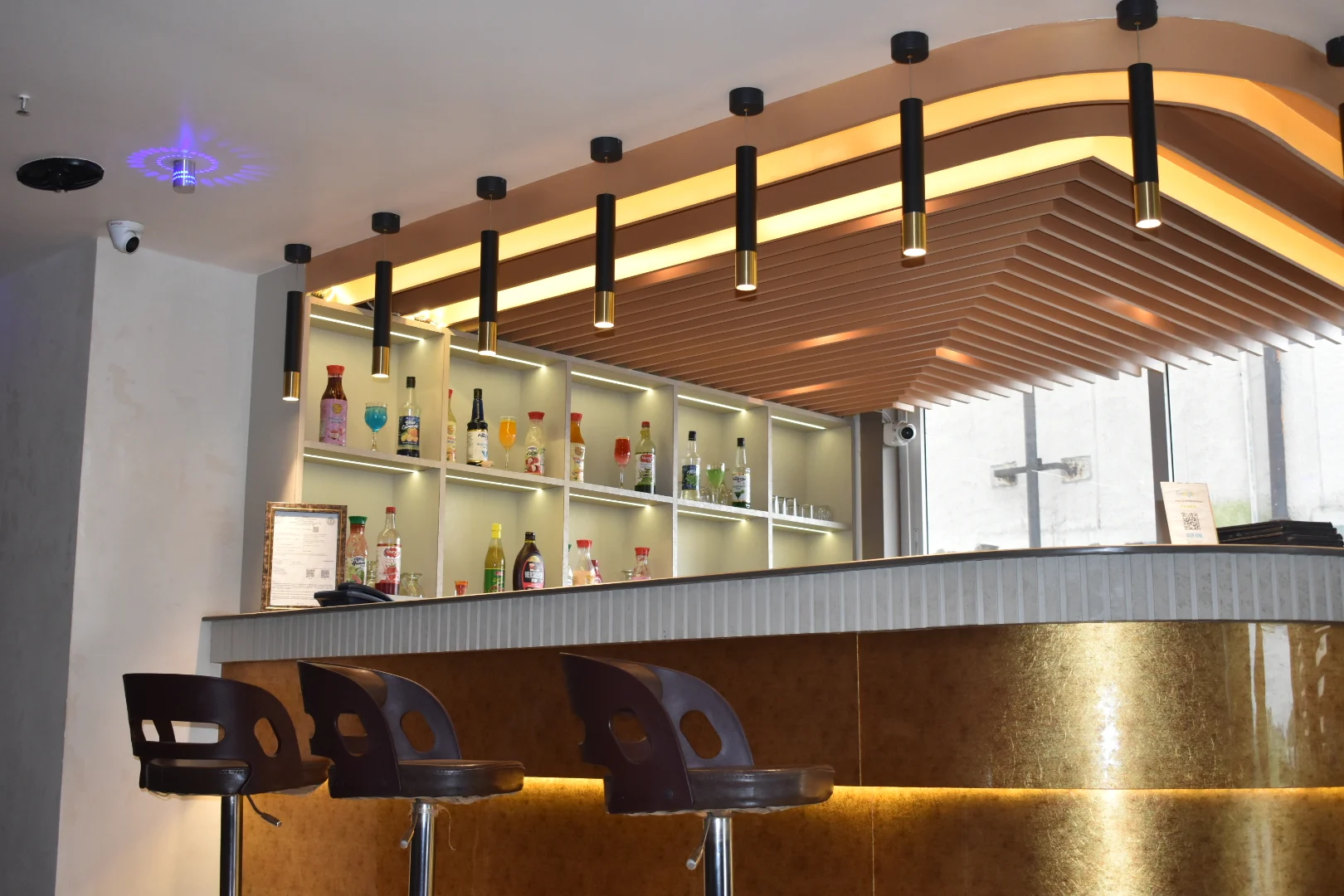 The illuminated gold bar and bar seating at Flavor Fusion